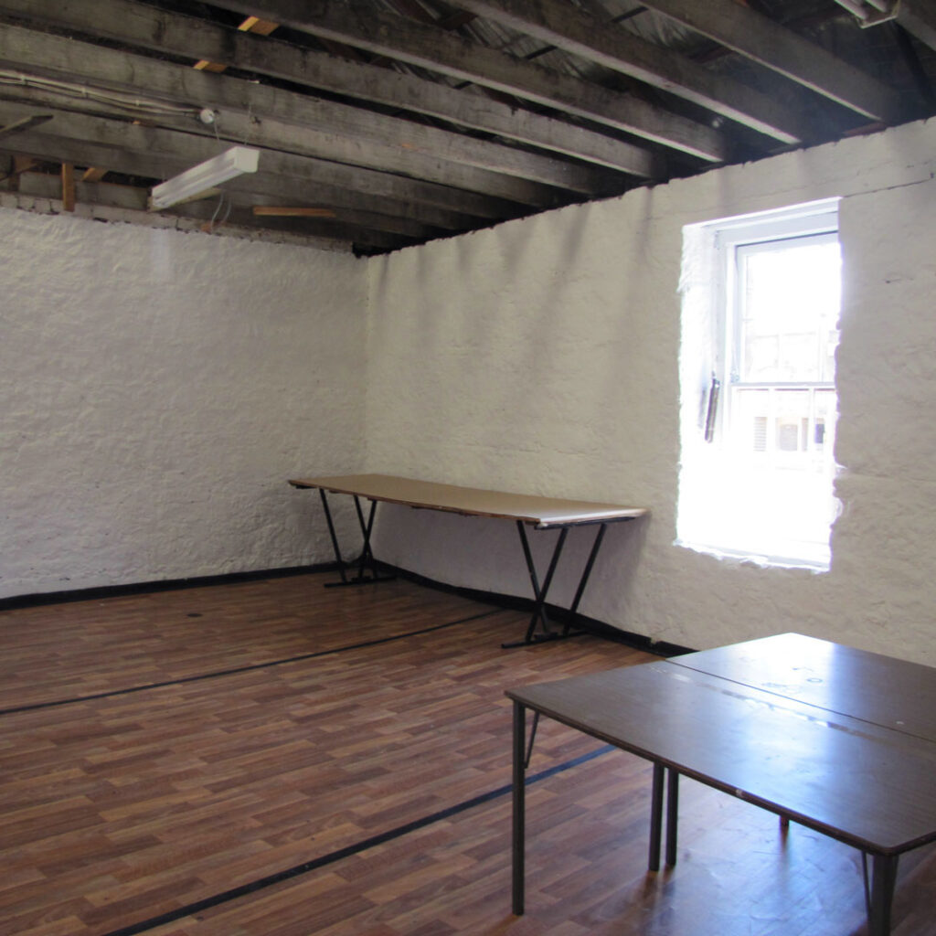 An empty artist's studio with exposed ceiling beams