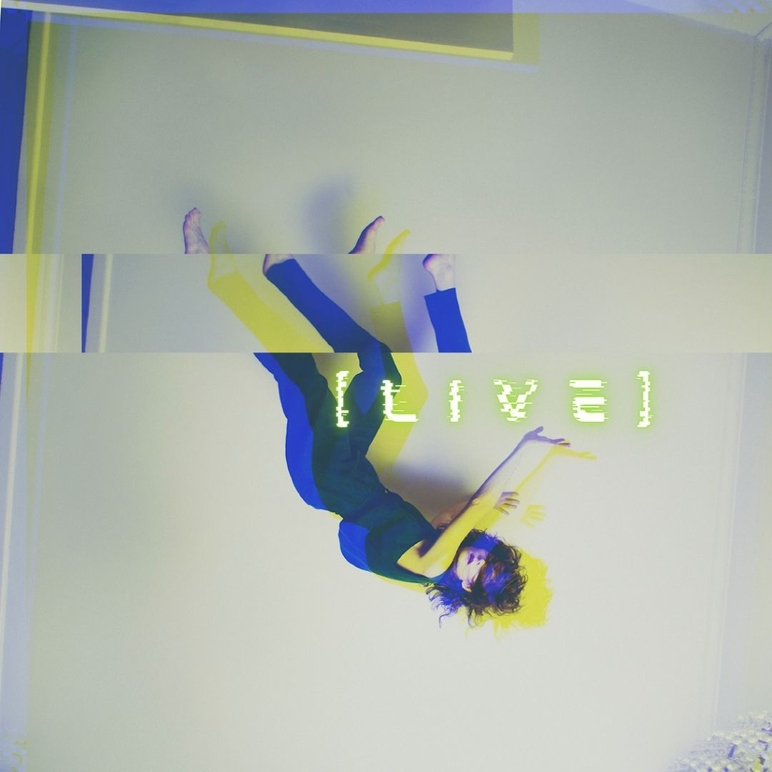 A woman looks to be frozen on the ceiling. She wears blue clothing and the word 'live' in yellow sits across the image.
