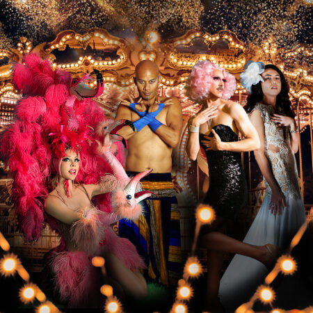 A group of performers wearing cabaret style clothing stare directly to the camera. Behind them is a horse carousel and fairy lights. the image is very saturated colour wise.