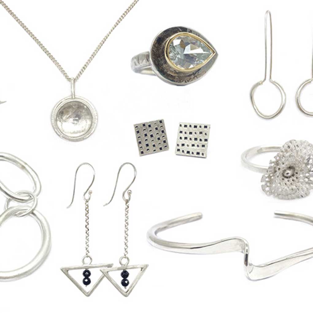 A selection of silver jewellery against a white background
