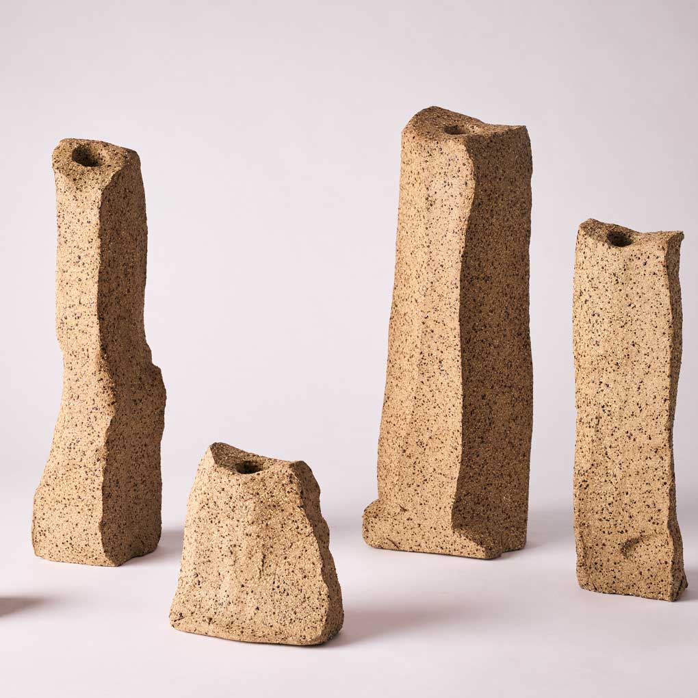 Irregular clay obelisk forms with a hollow centre, against a white background.