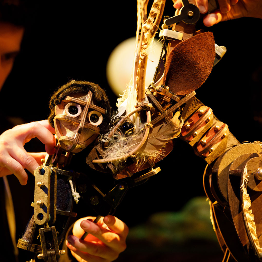 Image of a man and horse puppets made of small wooden pieces and scraps including feathers, bolts and leather.