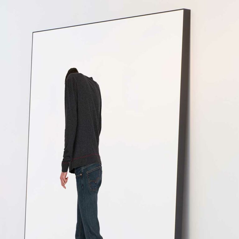 Large photographic print of a figure hunched over and turned away from view